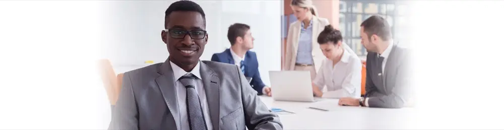 A professional in a suit leading a team meeting
