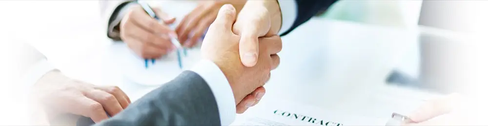 Two professionals shaking hands over a contract