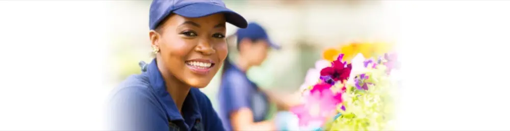 A smiling small business employee holding flowers