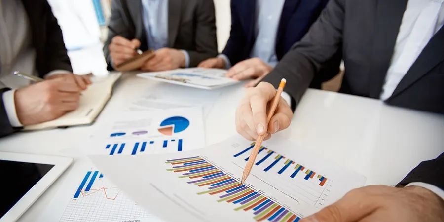 A team reviewing printed charts and reports around a table